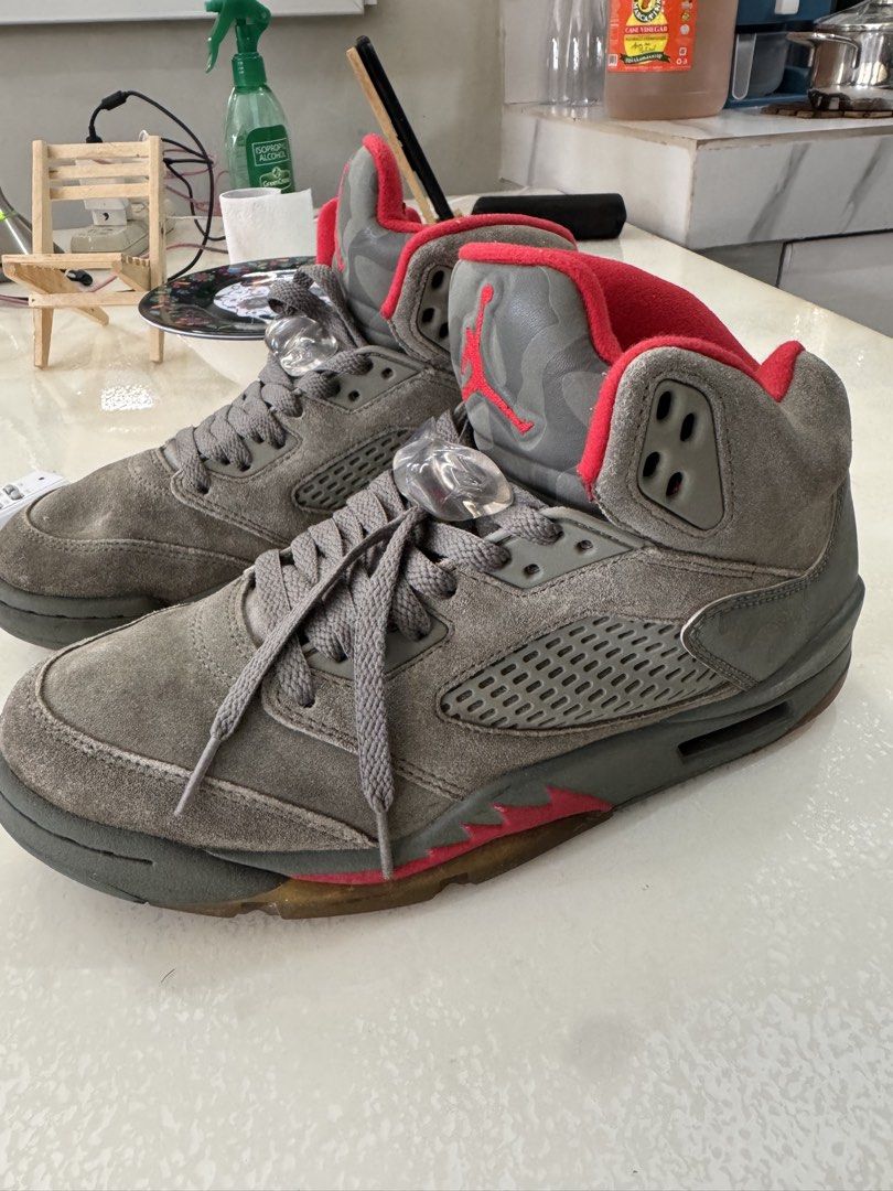 Air Jordan 5 Retro Camo Red (Category: Sneakers) located in Cavite. Submitted by marcuz1316 (Listing ID 1468750010, Image 2). Description: - Model: Nike Air Jordan 5 Retro - Colorway: Dark Grey Suede with Camouflage Print - Details: Vibrant red inner lining, embroidered Jumpman logo on the tongue, and Red Air 23 heel branding - Features: Classic mesh side panels, grey laces with clear lace locks - Sole: Translucent rubber outsole with signature r