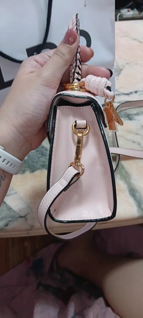 ALDO Pink Crossbody Bag with Top Handle (Category: Cross-body Bags) located in Pasig City. Submitted by elleiram05 (Listing ID 1468806498, Image 3). Description: - Authentic ALDO light pink handbag with chic black trim and gold-tone hardware - Features a trendy braided top handle and a detachable shoulder strap with side clips - Equipped with four protective metal feet on the bottom base - Spacious main compartment with a convenient internal zip 
