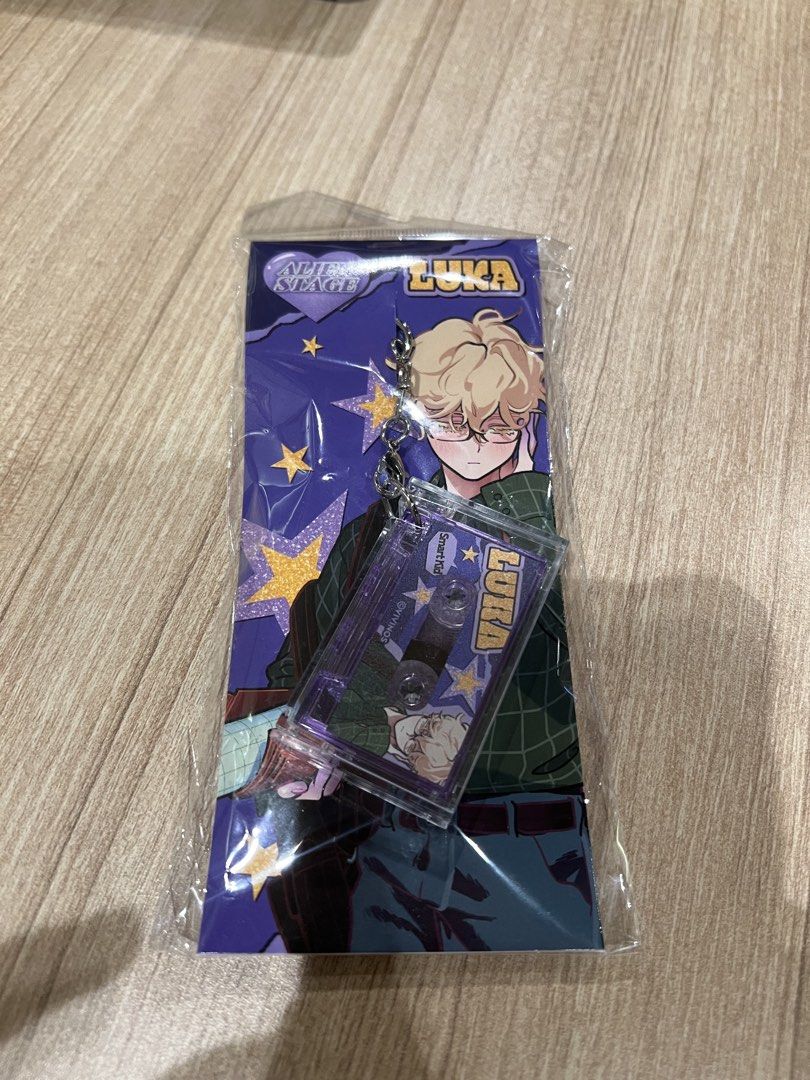 Alien Stage Till / Luka Cassette Keychain (Category: Character Goods) located in Mandaluyong City. Submitted by fluffycollections.ph (Listing ID 1468912916, Image 2). Description: ₱716each. - Official Alien Stage acrylic cassette keychains - Brand new and still sealed in original clear plastic packaging - Features a unique clear cassette design with character artwork inside - Perfect collectible merchandise for fans of the series.