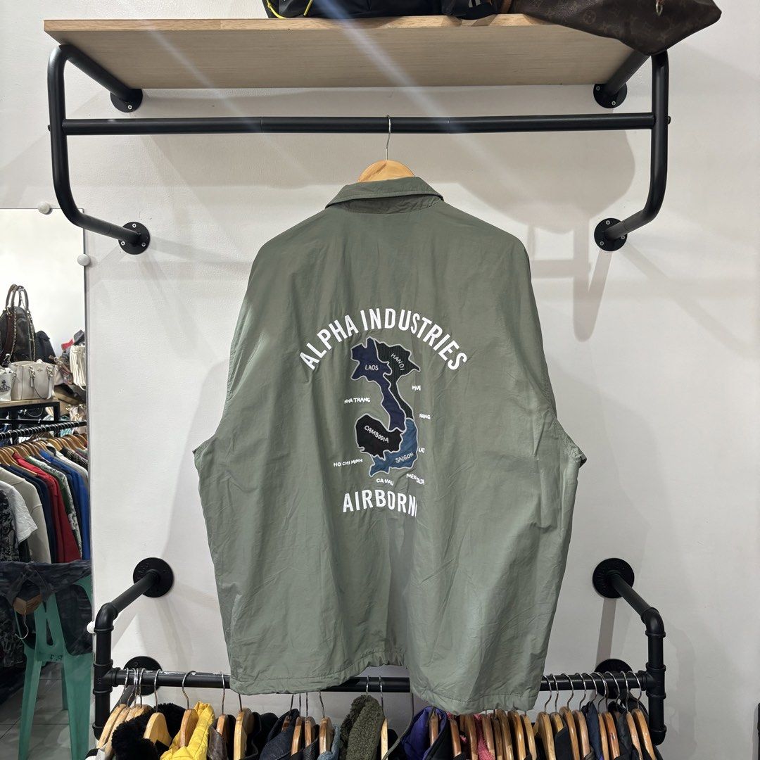 Alpha Industries Airborne Coach Sample Jacket Green XL (Category: Coats, Jackets and Outerwear) located in Bambang. Submitted by heats777 (Listing ID 1468828762, Image 3). Description: - Brand: Alpha Industries - Style: Coach jacket with snap button closure and side pockets - Color: Sage green - Size: XL - Details: Small chest logo patch, large graphic text and map print on the back - Lining: Quilted waffle fleece for extra warmth - Origin: Made 