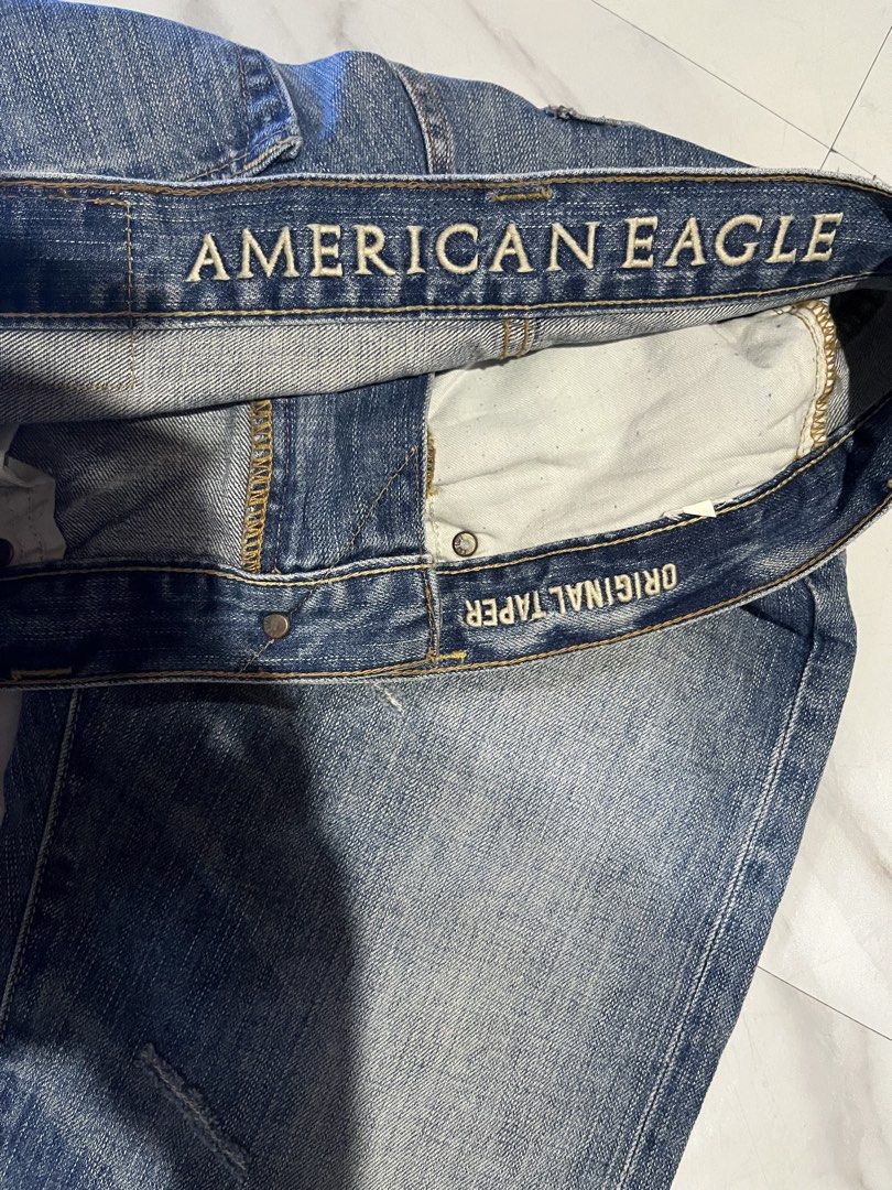 American Eagle Original Taper Jeans (Category: Jeans) located in Cavite. Submitted by christianzuuu (Listing ID 1468766855, Image 3). Description: - Brand: American Eagle - Fit: Original taper cut - Wash: Classic medium blue with factory distressing and whiskering - Closure: Button fly - Material: Sturdy, everyday-wear cotton - Measurements (laid flat): - Waist: 17 inches - Length: 42 inches - Leg opening: 11.5 inches - Condition: Excellent, read