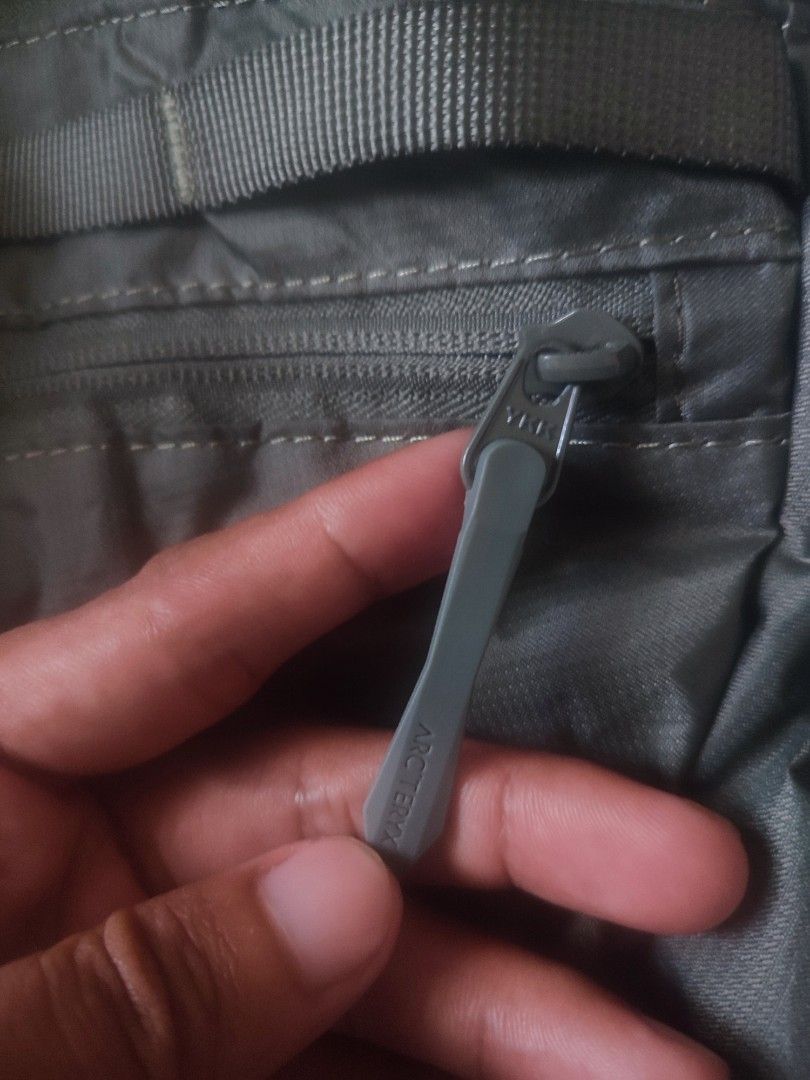 Arc'teryx Heliad 15 Backpack (Category: Backpacks) located in Sorsogon. Submitted by sergioslyughsome (Listing ID 1468726974, Image 3). Description: - Brand/Model: Arc'teryx Heliad 15 Backpack - Color: Sleek Grey - Design: Lightweight, minimalist daypack ideal for everyday commute or light trails - Features: Top grab handle, secure front zippered pocket with durable YKK hardware - Straps: Adjustable shoulder straps with black webbing - Condition: