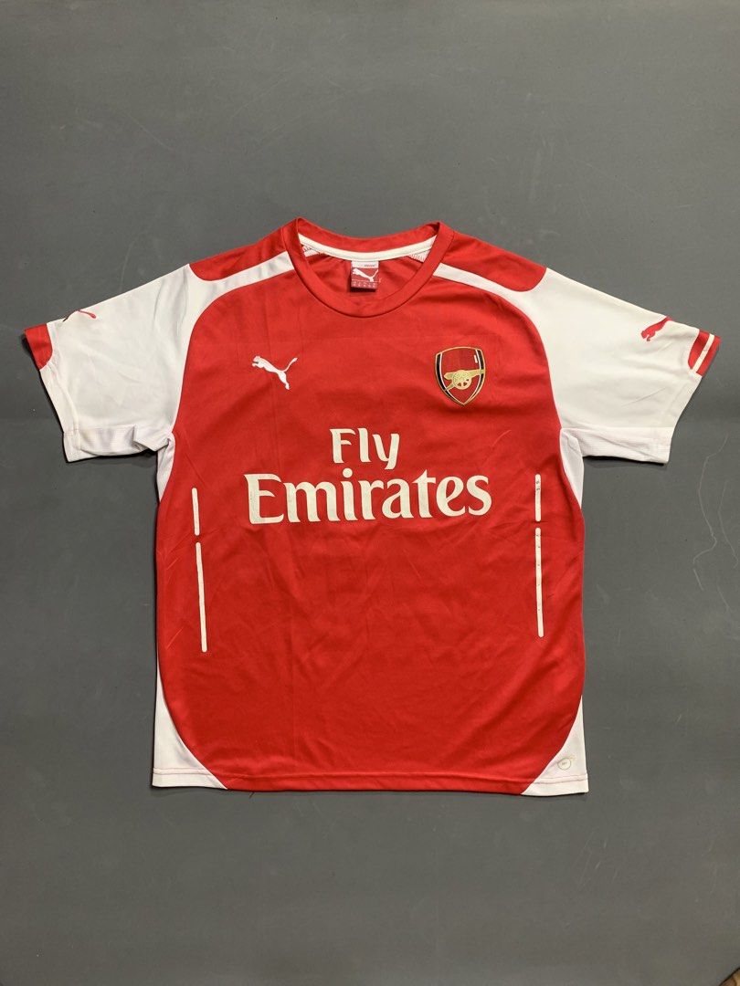 Arsenal Puma Fly Emirates Home Jersey (Category: Activewear) located in Kalibo. Submitted by gneiss2002 (Listing ID 1468752985, Image 1). Description: - Puma Arsenal home jersey - Iconic Fly Emirates chest sponsor - Classic red body with white sleeves and red Puma cats on shoulders - Stitched club crest and Puma logo - Comfortable round collar design - Must-have for Gunners fans and football kit collectors.