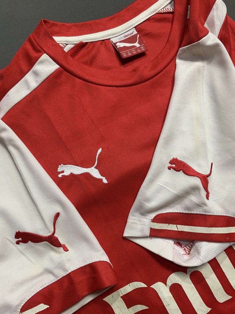 Arsenal Puma Fly Emirates Home Jersey (Category: Activewear) located in Kalibo. Submitted by gneiss2002 (Listing ID 1468752985, Image 3). Description: - Puma Arsenal home jersey - Iconic Fly Emirates chest sponsor - Classic red body with white sleeves and red Puma cats on shoulders - Stitched club crest and Puma logo - Comfortable round collar design - Must-have for Gunners fans and football kit collectors.