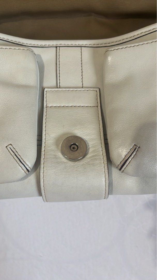 Authentic Coach White Soho Bag (Category: Luxury Bags & Wallets) located in Davao. Submitted by peewhoop (Listing ID 1468796139, Image 3). Description: - Brand: Coach - Color: White leather with brown fabric lining - Hardware: Silver-tone with front buckle closure - Inclusions: Matching white leather hangtag - Condition: Clean exterior with minimal signs of handling on hardware - Style: Compact and versatile for everyday use.