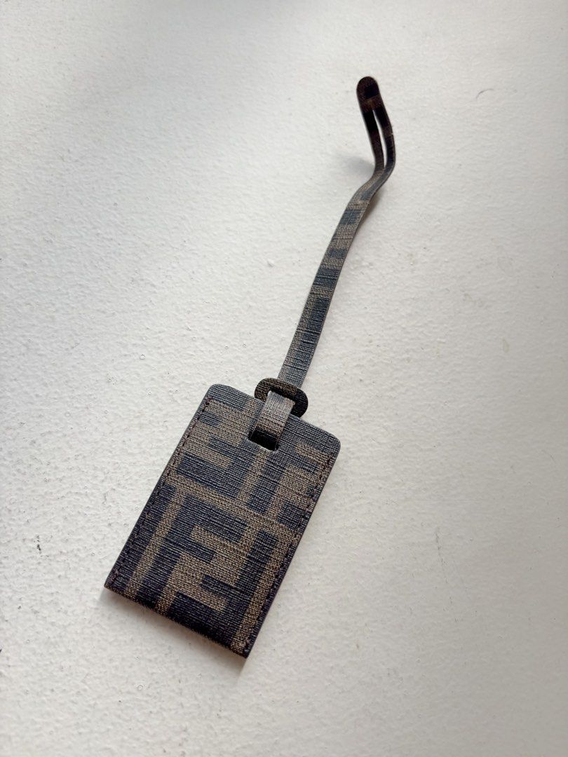 Authentic Fendi FF Zucca Bag Tag (Category: Luxury Bags & Wallets) located in Mandaluyong City. Submitted by wear_your_style (Listing ID 1468794309, Image 2). Description: Bought in Japan. Coated canvas material/PVC. Perfect for your carry-on luggage or sa everyday bag mo. You can insert your ID or photo inside for identifier. Approx 3.2 inches long and 2.2 inches wide. Flat type. No issues, signs if use if any. RFS: decluttering.