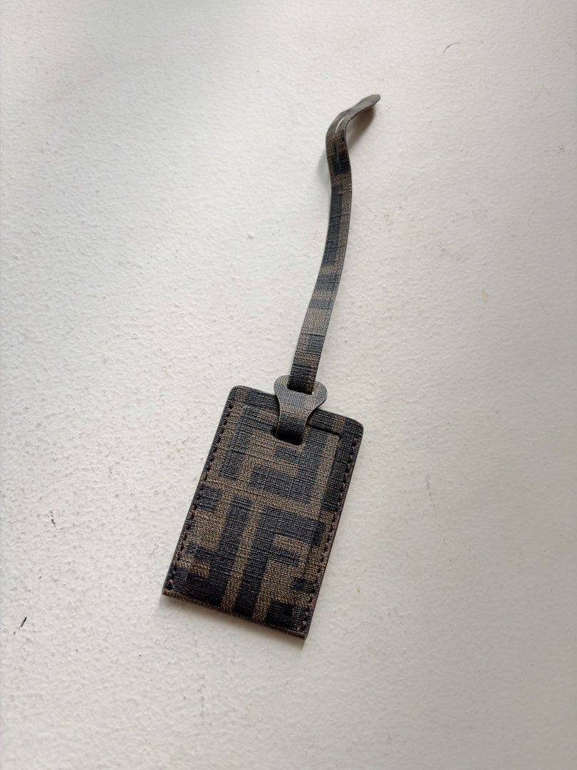 Authentic Fendi FF Zucca Bag Tag (Category: Luxury Bags & Wallets) located in Mandaluyong City. Submitted by wear_your_style (Listing ID 1468794309, Image 1). Description: Bought in Japan. Coated canvas material/PVC. Perfect for your carry-on luggage or sa everyday bag mo. You can insert your ID or photo inside for identifier. Approx 3.2 inches long and 2.2 inches wide. Flat type. No issues, signs if use if any. RFS: decluttering.