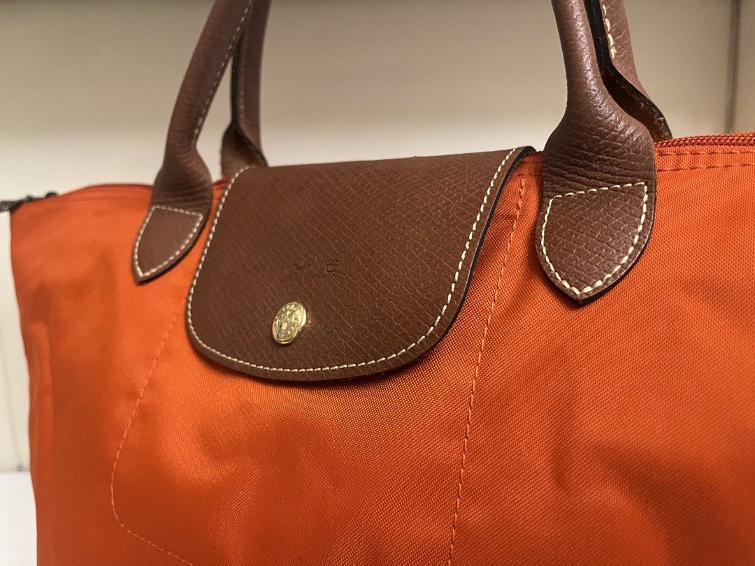 Authentic Longchamp Le Pliage – Orange (Category: Purses & Pouches) located in Manila. Submitted by bellejnc (Listing ID 1468811868, Image 1). Description: Decluttering sale because I’m moving out of the country! ✈️ Selling some of my personal belongings and hoping they find a new home. ✨ Authentic Longchamp Le Pliage 🧡 Color: Orange 🇪🇺 Purchased in Europe 💰 Selling for only ₱3,000 Condition: Pre-loved. There is a stain on the bag that may be