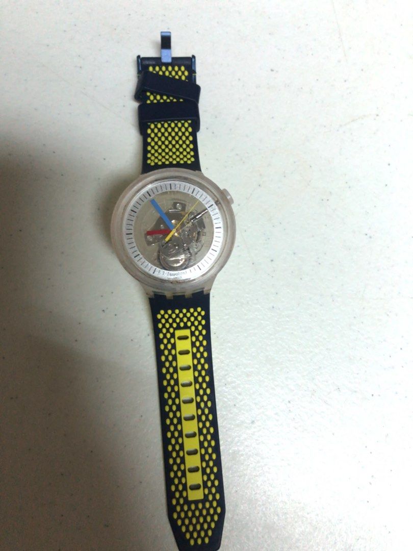 Authentic Swatch Watch (Category: Men's Watches) located in Muntinlupa City. Submitted by ybmcloset2230 (Listing ID 1468716553, Image 2). Description: Swatch — Swiss made ✅ • Style: Skeleton dial — you can see the movement inside! Clear transparent case • Cool red/blue/yellow hands • Navy blue strap with bright yellow dot pattern — sporty & fun design • Condition: Looks clean — transparent case clear, strap intact Pre-loved Swatch Skeleton) ⌚ Swa