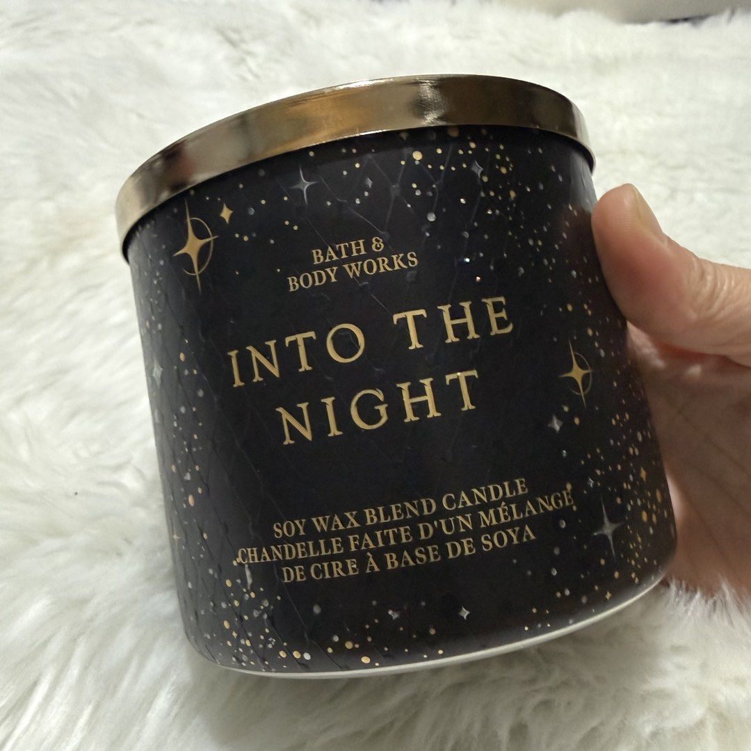 Bath & Body Works Into The Night 3-Wick Candle (Category: Home Fragrance) located in Pasig City. Submitted by mommy_n_me_closet (Listing ID 1468801461, Image 1). Description: - Brand: Bath & Body Works - Fragrance: Into The Night (Sugared Raspberry, Velvet Rose Petals, Shimmering Amber, Creamy Musk) - Size: 14.5 oz / 411 g (3-Wick Candle) - Wax: Soy wax blend - Packaging: Dark starry night jar design with a gold lid - Condition: 100% brand new, u