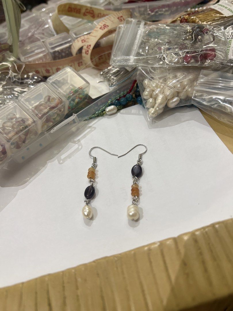 Beaded dangles with freshwater pearls and gemstone chips (Category: Earrings) located in Quezon City. Submitted by iminquezoncity (Listing ID 1468847550, Image 1). Description: - Handmade asymmetric design - Features freshwater pearls, dark purple stones, and orange amber chips - Silver-toned hooks - Lightweight and comfortable for daily wear - Length: approximately 2 inches.