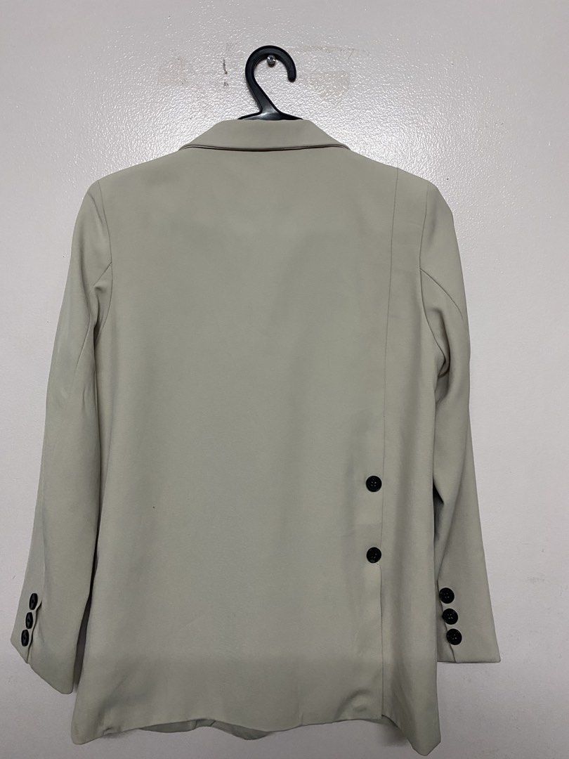 Beige Double Breasted Blazer with Back Buttons (Category: Coats, Jackets and Outerwear) located in Taytay. Submitted by themissmj (Listing ID 1468902843, Image 2). Description: - Color: Clean neutral beige - Design: Double-breasted front with contrasting dark buttons - Fit & Structure: Structured shoulders and classic lapel collar - Interior: Fully lined for comfort - Pockets: Front welt pockets and a single chest pocket - Unique Details: Decorat