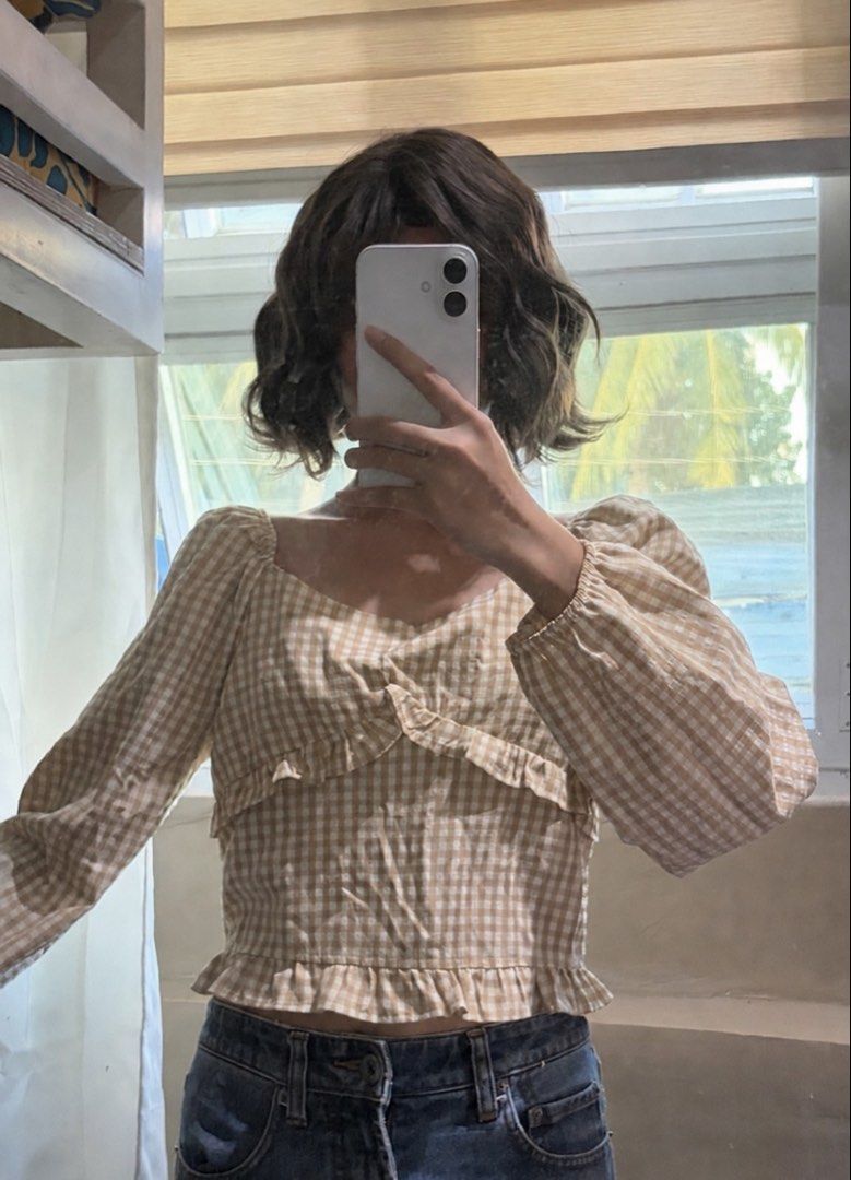 Beige Gingham Square Neck Long Sleeve Crop Top (Category: Longsleeves) located in San Mateo. Submitted by heiayafinds (Listing ID 1468832514, Image 2). Description: - Color/Pattern: Beige and white gingham print - Neckline: Sweetheart neckline with front ruffle details - Sleeves: Long sleeves with comfortable elastic cuffs - Fit: Cropped length with a stylish ruffled hem - Styling Tip: Pairs easily with your favorite high-waisted jeans.