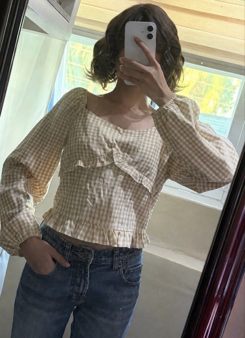 Beige Gingham Square Neck Long Sleeve Crop Top (Category: Longsleeves) located in San Mateo. Submitted by heiayafinds (Listing ID 1468832514, Image 3). Description: - Color/Pattern: Beige and white gingham print - Neckline: Sweetheart neckline with front ruffle details - Sleeves: Long sleeves with comfortable elastic cuffs - Fit: Cropped length with a stylish ruffled hem - Styling Tip: Pairs easily with your favorite high-waisted jeans.