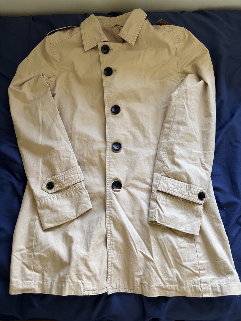 Beige Trench Coat Jacket with Black Buttons (Category: Coats, Jackets and Outerwear) located in Manila. Submitted by prelovedbykleng (Listing ID 1468849557, Image 1). Description: Fits S-M - Color: Beige - Closure: Large black front buttons - Features: Collared neck, shoulder epaulets, and buttoned cuff straps - Style: Clean, versatile, and easy to match with most outfits - Season: Great layering piece for cooler weather.