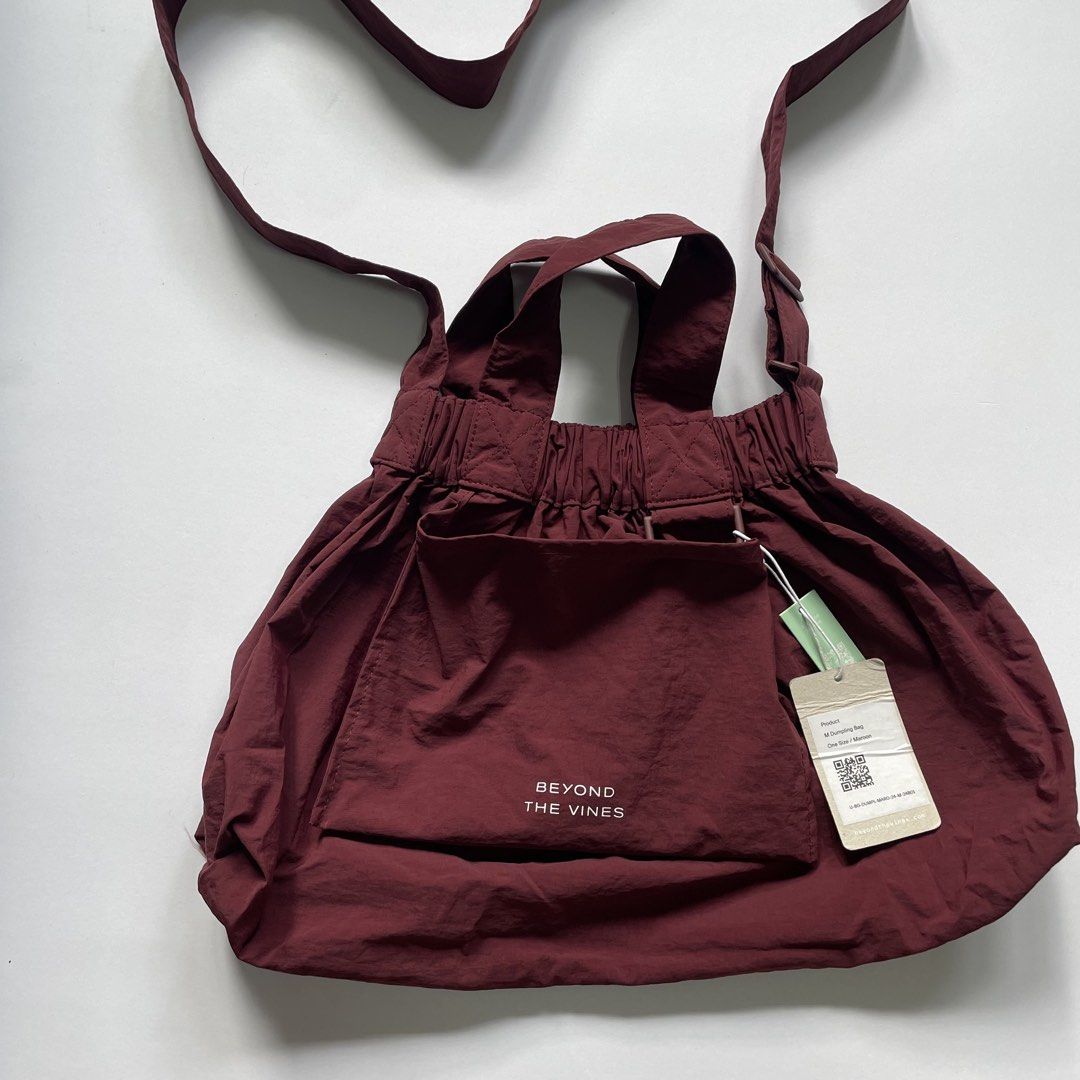 Beyond The Vines M Dumpling Bag Maroon (Category: Shoulder Bags) located in Pasay City. Submitted by lovedbyzea (Listing ID 1468785680, Image 2). Description: - Brand: Beyond The Vines - Style: M Dumpling Bag - Color: Maroon - Condition: Brand new with tags (BNWT) - Size: Medium, perfect everyday carryall - Material: Lightweight and durable nylon - Features: Packs into its own front pocket, adjustable crossbody strap, top handle grab loops, secur