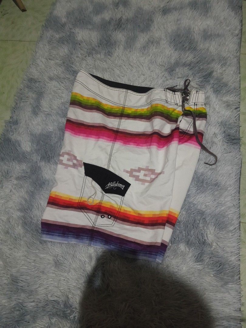 Billabong Board Shorts Aztec Print Size 38 (Category: Swim Trunks & Board Shorts) located in Lingayen. Submitted by rahzzelula73279 (Listing ID 1468727898, Image 2). Description: - Brand: Billabong - Size: 38 - Material: 100% Polyester (Made in China) - Design: White base with vibrant horizontal stripes and Aztec diamond graphics - Closure: Adjustable drawstring waist - Pockets: Velcro side pocket with signature embroidered logo tag - Care: Cold 