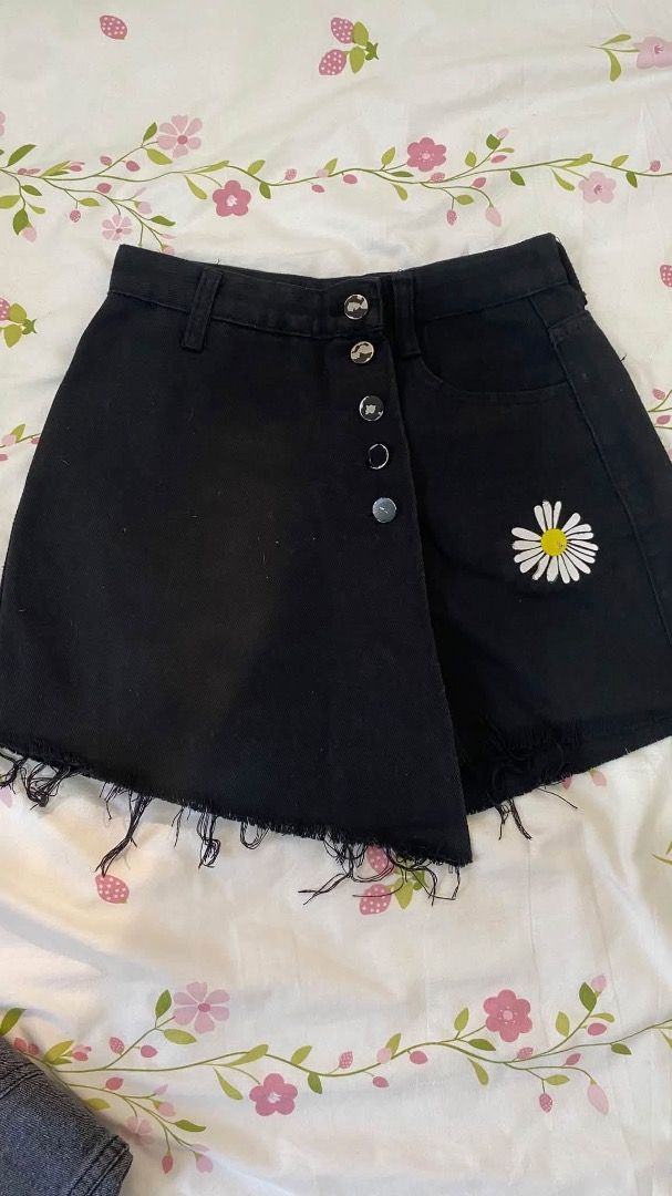 Black denim skort with daisy patch and frayed hem (Category: Skirts) located in Caloocan City. Submitted by lianarchiveee (Listing ID 1468713478, Image 1). Description: - Color: Black denim - Style: Wrap skirt with button-up front and mid-rise waist - Details: White and yellow daisy patch on the right side, raw frayed hem - Fit: Includes belt loops - Condition: Brand new / Excellent (ready to wear) - Perfect for: Casual days out and weekend styli