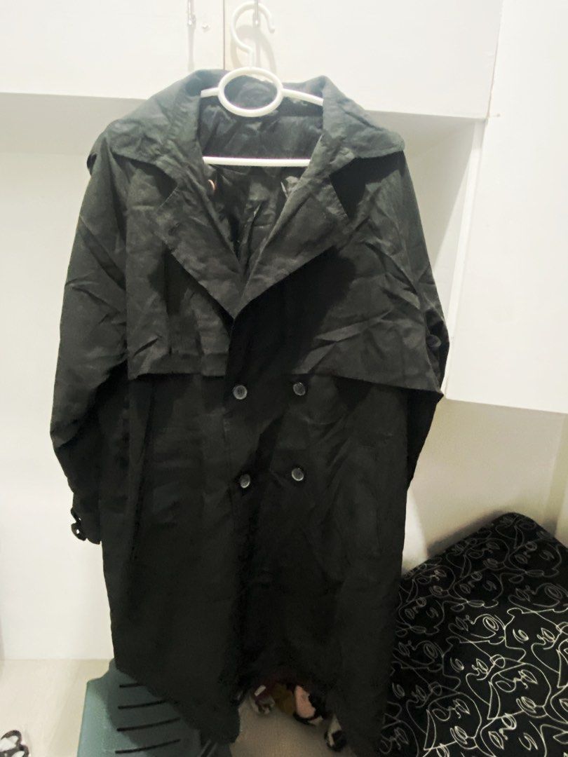 Black Double-Breasted Trench Coat (Category: Coats, Jackets and Outerwear) located in Manila. Submitted by abbyyey (Listing ID 1468773071, Image 3). Description: - Classic solid black trench coat - Double-breasted button closure with wide lapels - Long sleeves featuring adjustable cuffs - Storm flap across the back - Fully lined interior for comfort - Essential layering piece for cooler weather - DM for measurements or more details!.