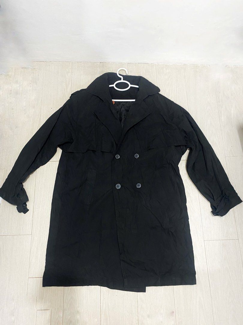 Black Double-Breasted Trench Coat (Category: Coats, Jackets and Outerwear) located in Manila. Submitted by abbyyey (Listing ID 1468773071, Image 2). Description: - Classic solid black trench coat - Double-breasted button closure with wide lapels - Long sleeves featuring adjustable cuffs - Storm flap across the back - Fully lined interior for comfort - Essential layering piece for cooler weather - DM for measurements or more details!.
