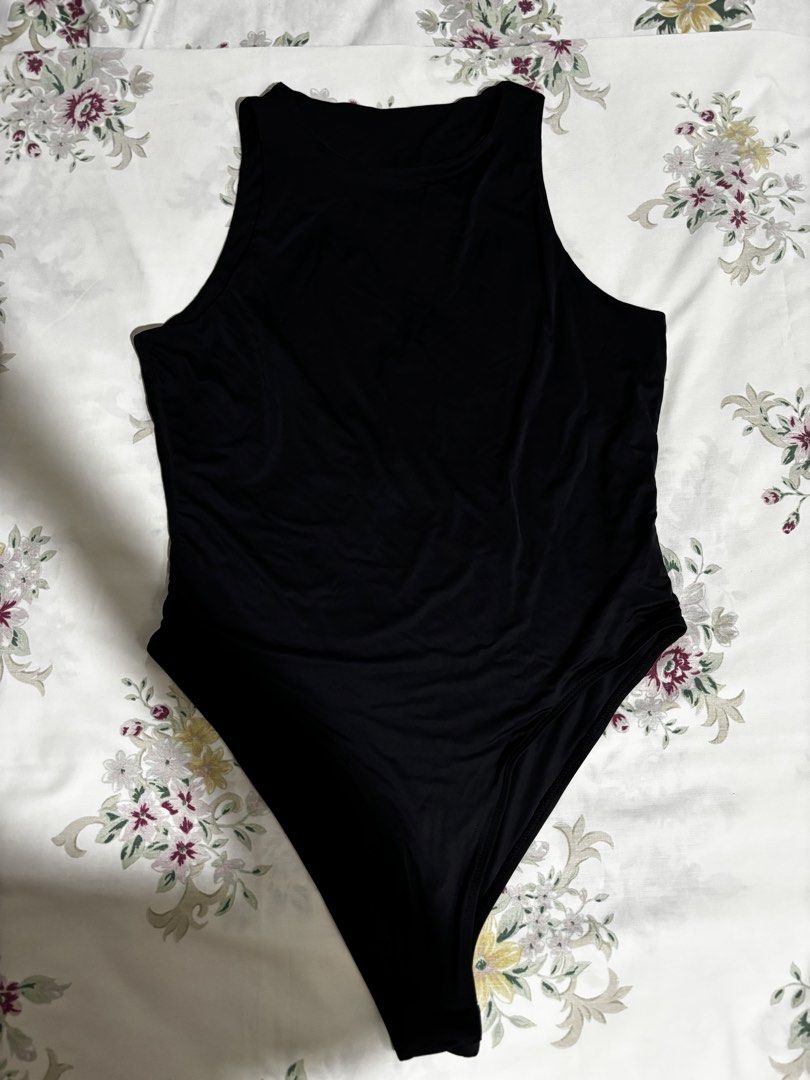 Black high neck sleeveless bodysuit (Category: Sleeveless) located in Pasig City. Submitted by closetcleanoutmnl (Listing ID 1468779074, Image 1). Description: - Color: Solid Black - Style: Sleeveless with a trendy high neckline - Fit: Stretchy, smooth, and body-hugging - Closure: Bottom snap buttons for easy wear - Versatility: Perfect for pairing with denim, shorts, or skirts.