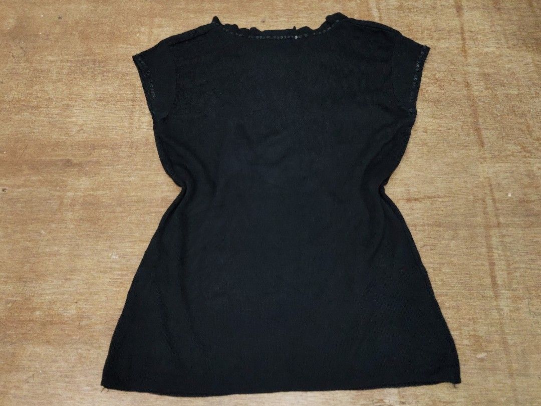 Black Knit Blouse with Sequin and Ruffle Details (Category: Blouses) located in San Juan City. Submitted by rhennx (Listing ID 1468903752, Image 3). Description: - Color: Black - Material: Stretchy ribbed knit fabric for a comfy fit - Design: Short sleeves with button-down front - Accents: Eye-catching ruffle panel and collar lined with small shiny sequins - Versatility: Great for casual outings or dressed up for the evening.