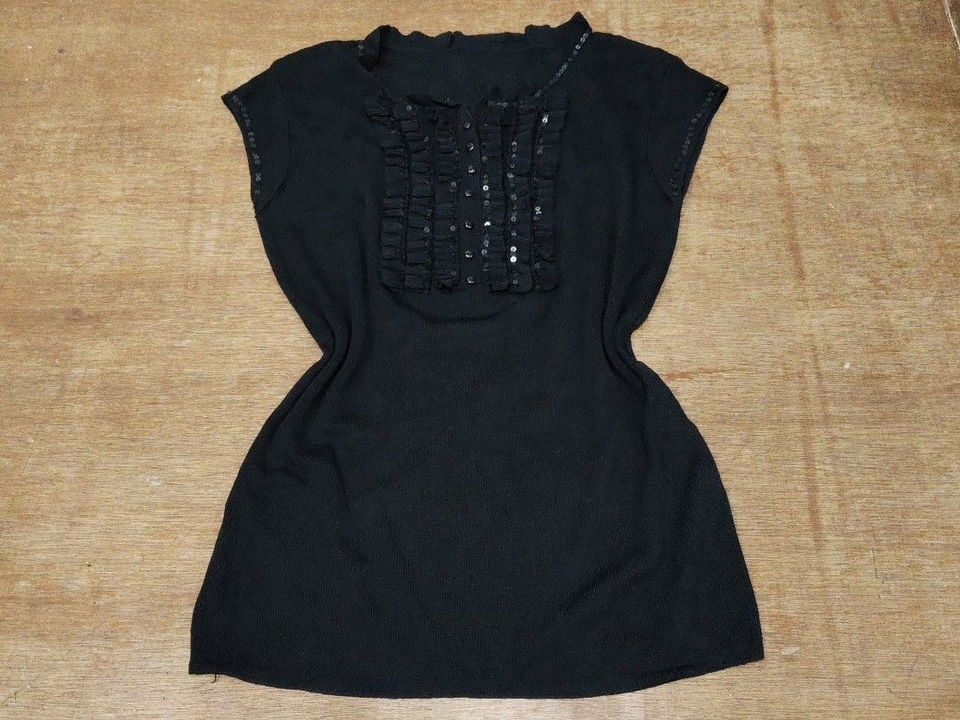 Black Knit Blouse with Sequin and Ruffle Details (Category: Blouses) located in San Juan City. Submitted by rhennx (Listing ID 1468903752, Image 1). Description: - Color: Black - Material: Stretchy ribbed knit fabric for a comfy fit - Design: Short sleeves with button-down front - Accents: Eye-catching ruffle panel and collar lined with small shiny sequins - Versatility: Great for casual outings or dressed up for the evening.
