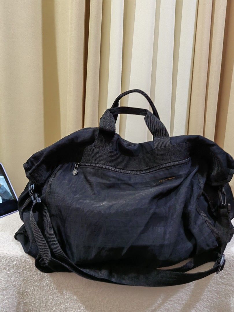 Black nylon duffle bag with shoulder strap (Category: Sling Bags) located in Makati City. Submitted by prelovedtreatedwithlove (Listing ID 1468890962, Image 3). Description: - Material: Durable and lightweight black nylon - Capacity: Super spacious main compartment with a big front zipper pocket 22inches length. SUPER XL malaki - Versatility: Ideal for gym sessions, weekend trips, travel use - Design: Soft, packable body that folds down completel