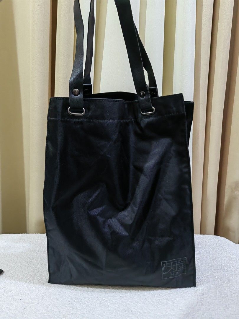 Black Nylon Tote Bag (Category: Tote Bags) located in Makati City. Submitted by prelovedtreatedwithlove (Listing ID 1468888637, Image 2). Description: - Color: Solid black - Material: Lightweight, durable, and fold-friendly nylon - Capacity: Spacious square shape - Condition:Excellent A-172.