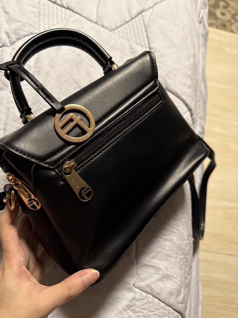 Black Quilted Heart Handbag (Category: Luxury Bags & Wallets) located in Caloocan City. Submitted by tootsief (Listing ID 1468865842, Image 2). Description: - Style: Structured black handbag with a trendy quilted heart pattern on the front flap - Hardware: Elegant gold-tone accents including a front metal bar, logo charm, and zipper pulls - Versatility: Comes with a sturdy top handle and a detachable, adjustable shoulder strap - Storage: Multiple