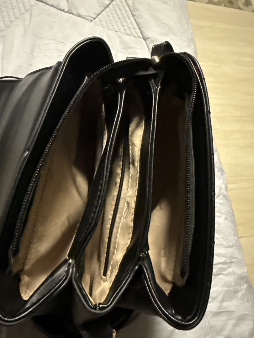 Black Quilted Heart Handbag (Category: Luxury Bags & Wallets) located in Caloocan City. Submitted by tootsief (Listing ID 1468865842, Image 3). Description: - Style: Structured black handbag with a trendy quilted heart pattern on the front flap - Hardware: Elegant gold-tone accents including a front metal bar, logo charm, and zipper pulls - Versatility: Comes with a sturdy top handle and a detachable, adjustable shoulder strap - Storage: Multiple