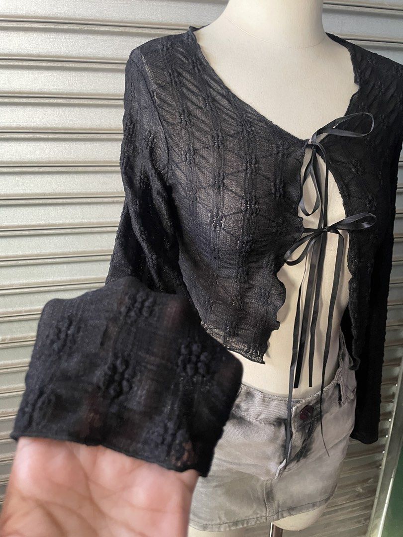 Black sheer textured tie-front crop top (Category: Blouses) located in Davao. Submitted by riab_qt (Listing ID 1468776683, Image 3). Description: - Color: Black - Style: Sheer long-sleeve crop top with V-neckline - Details: Front tie closure with dual black satin ribbons and lettuce-hem edges - Fabric: Lightweight and slightly see-through - Fit: True to size; ideal for layering or going-out fits.