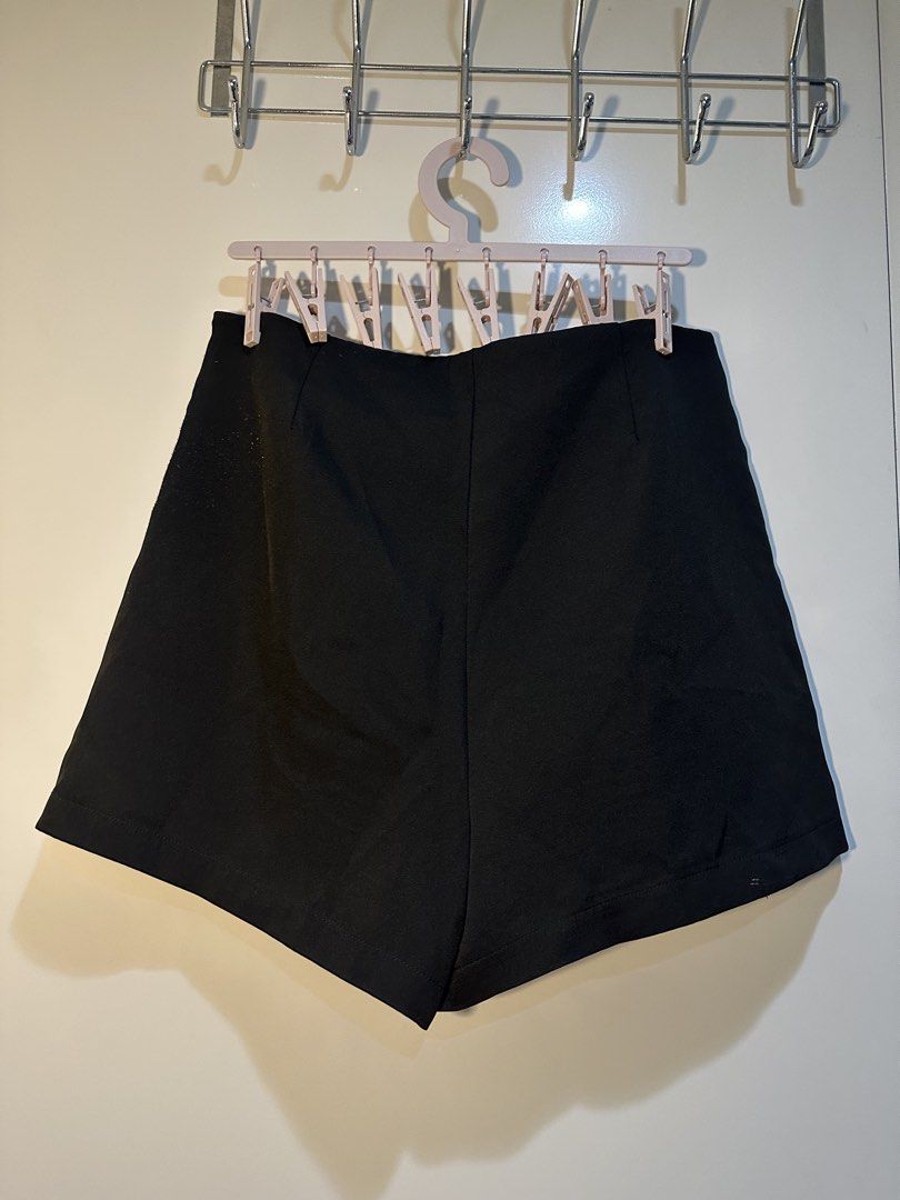 Black shorts skort with side stripe detail (Category: Shorts) located in Taguig. Submitted by ellajanee (Listing ID 1468777592, Image 1). Description: - Color: Black - Style: High-waisted skort with clean front flap overlay and pleat accents - Details: Chic satin side stripes on both legs, back darts for a flattering shape - Closure: Convenient side zip - Versatility: Easy to pair with basic tees or blouses for casual days - Condition: Brand new 