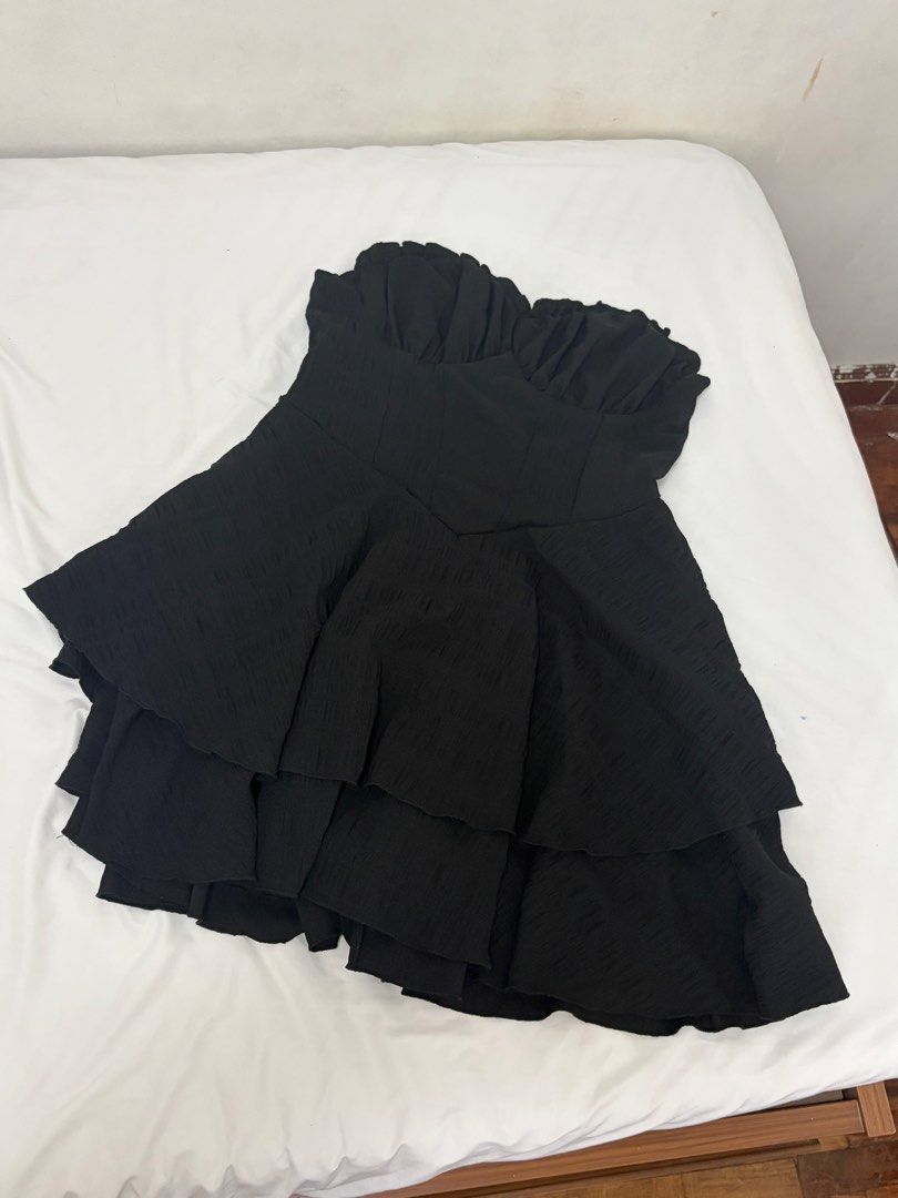 Black Strapless Ruffle Tiered Mini Dress (Category: Dresses) located in Las Pinas. Submitted by thriftedfinds_ (Listing ID 1468868959, Image 2). Description: - Style: Black strapless party dress - Neckline: Sweetheart neckline with gathered bust detail - Skirt: Multi-layered ruffled skirt for a voluminous, flared shape - Fabric: Textured material throughout - Fit: Easy pull-on style - Occasion: Ideal for parties, nights out, or dates - Versatilit