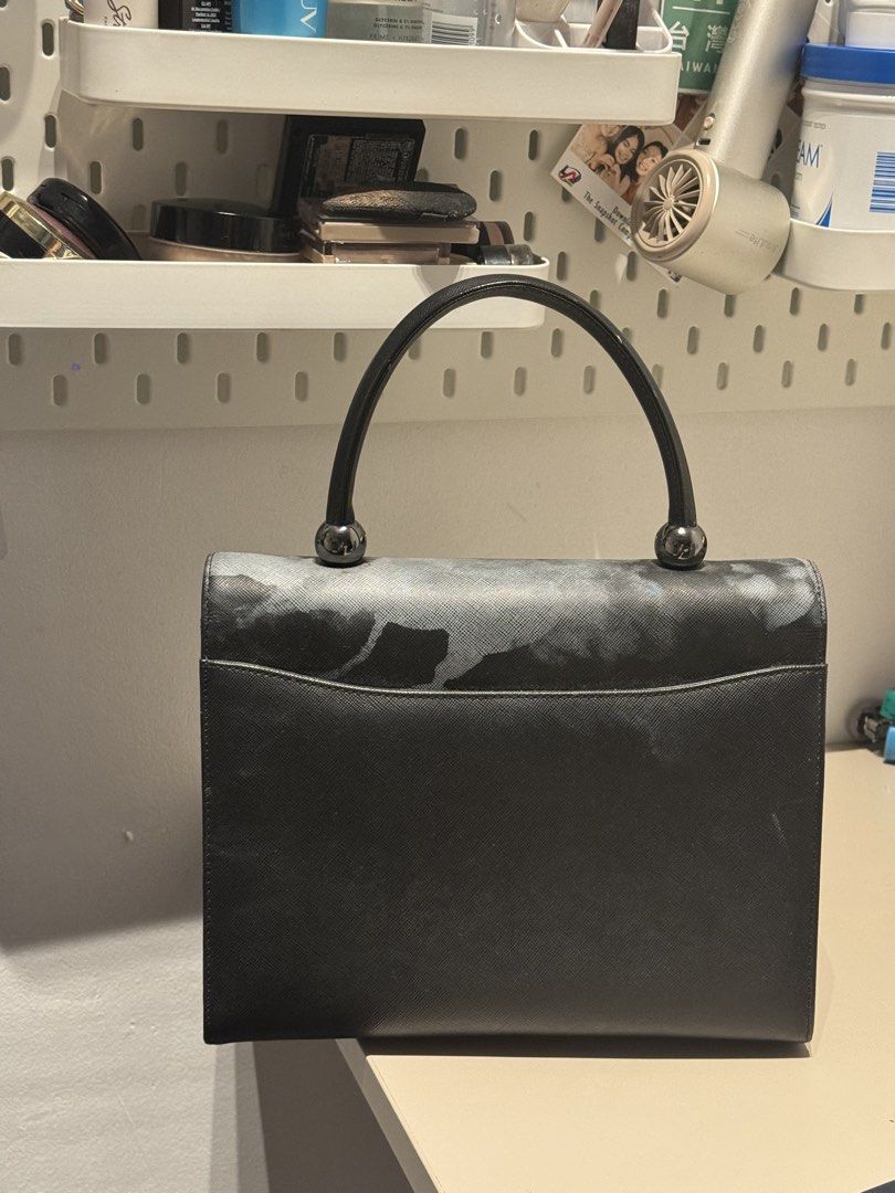 Black Structured Top Handle Handbag (Category: Tote Bags) located in Manila. Submitted by aloueueueu (Listing ID 1468873584, Image 2). Description: For free if you purchase anything from me (PHP 300 minimum)! Can only do meetups around BGC or delivery around Metro Manila (or wherever Lalamove can reach) - Color & Texture: Structured black bag with a sleek saffiano finish - Design: Single round handle with chic metal ball accents at the base - Clo