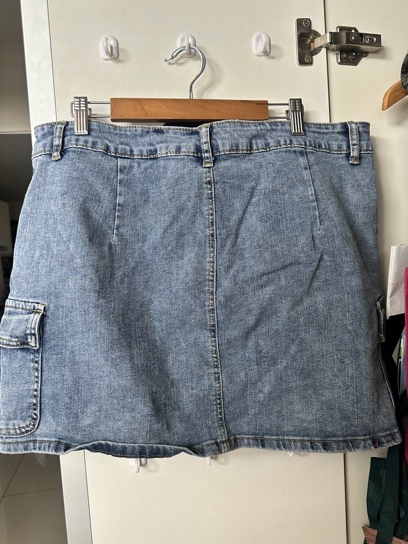 Blue Denim Cargo Skirt with Side Pockets Size M (Category: Skirts) located in Caloocan City. Submitted by be.iiiii (Listing ID 1468828947, Image 3). Description: - Style: Medium wash denim cargo skirt - Details: Front zip and button closure, belt loops, and panel stitching on the back - Pockets: Functional utility side pockets on both hips - Accent: Small turquoise embroidered logo near the bottom left hem - Fit: Classic mid-rise - Pairing: Great