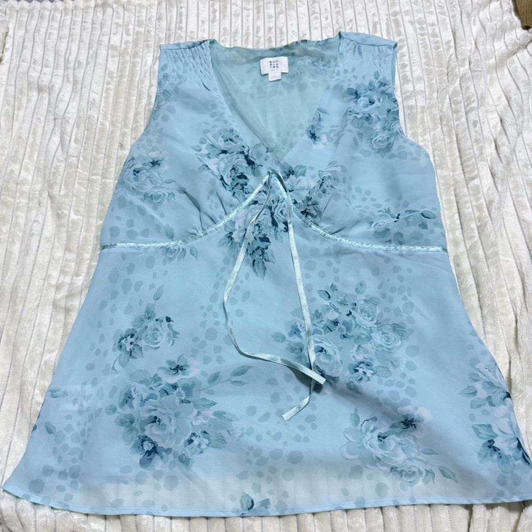 Blue Floral Chiffon Tank Top (Category: Sleeveless) located in Manila. Submitted by ish.core (Listing ID 1468876965, Image 1). Description: - Brand: Apt. 9 - Size: M - Y2K-vibe, perfect with skirts - L: 24in, Bust: 15in - Color: Light blue with floral pattern - Style: Sleeveless, V-neck with under-bust ribbon tie, gathered shoulders - Material: Sheer fabric (great for layering or warm weather) - Condition: Excellent.