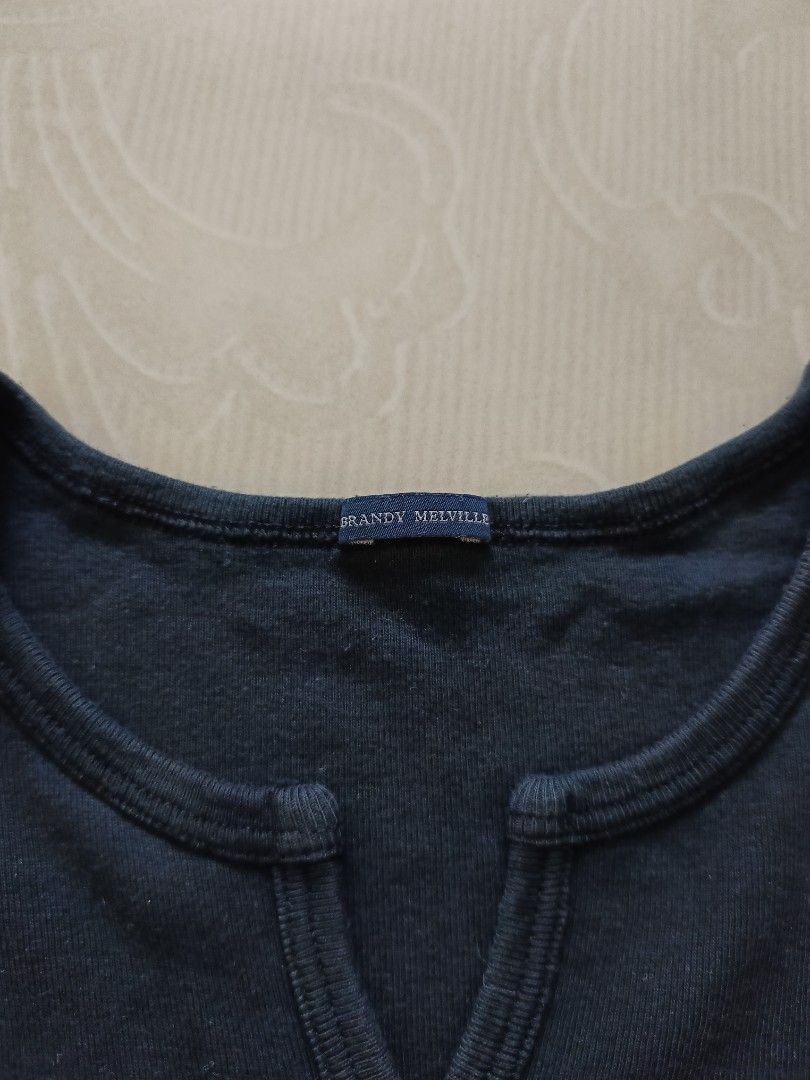 Brandy Melville Black Short Sleeve Top (Category: Shirts) located in Cabanatuan. Submitted by lyxyx (Listing ID 1468722717, Image 2). Description: - Brand: Brandy Melville - Color: Black - Style: Short sleeve top with scoop neckline and front slit detail - Fabric: Ribbed texture - Condition: Brand new with tag attached - Perfect basic staple, easy to pair with high-waisted jeans or skirts.