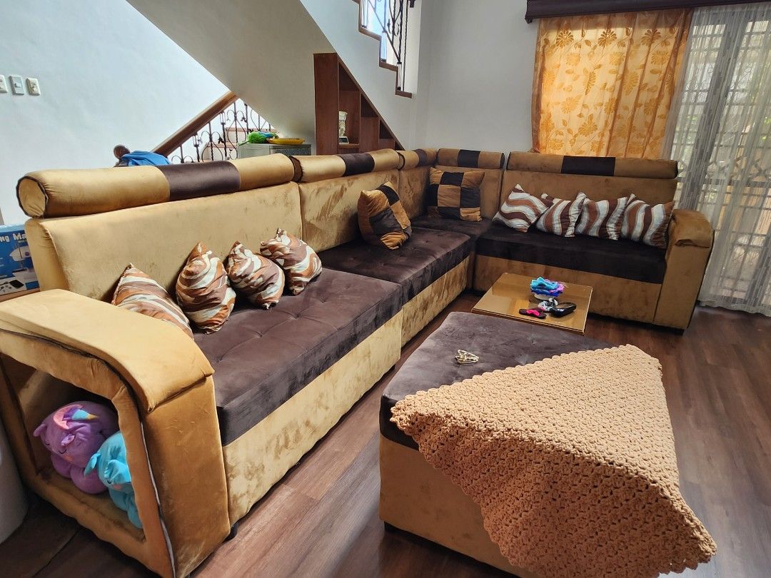 Customized 6 inch Uratex foam Sectional Sofa with Coffee Table and Stools (Category: Sofas) located in Tarlac. Submitted by til128 (Listing ID 1468847146, Image 1). Description: - Complete Living Room Set: Large sectional sofa in brown and gold velvet fabric - Smart Storage: Built-in storage armrest section included - Matching Accessories: Comes with multiple patterned throw pillows - Coffee Table: Glass-top center table with built-in shelving - 