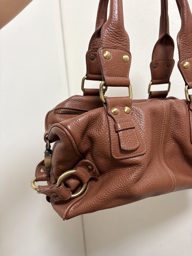 Brown Leather Shoulder Bag (Category: Shoulder Bags) located in Cabuyao City. Submitted by mhd.i (Listing ID 1468877075, Image 2). Description: Condition: Good preloved condition with signs of use. DM for more photos! Hardware: Features brass-tone metal accents. Please note there is noticeable tarnishing, color fading, and minor green oxidation on the rivets and buckles as shown in the photos. The zippers are fully functional. Leather: Soft, pebb