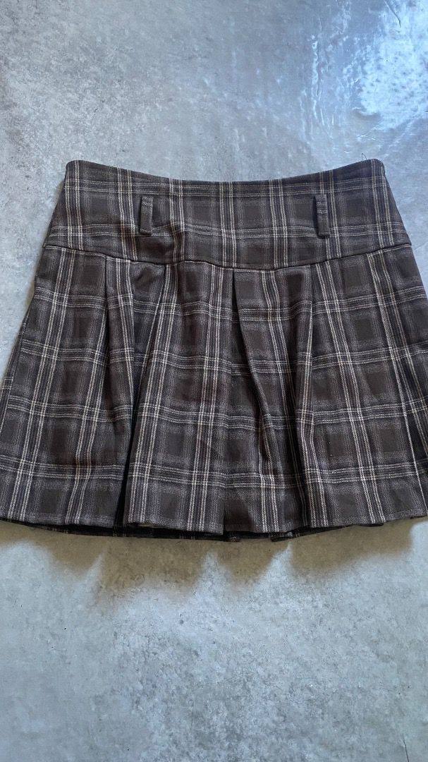 Brown Plaid Pleated Mini Skirt (Category: Skirts) located in Caloocan City. Submitted by lianarchiveee (Listing ID 1468713837, Image 1). Description: - Brown plaid pleated mini skirt with white grid checks - Fitted yoke waistband featuring convenient belt loops - Short box pleats for a flared, stylish hemline - Soft and cozy woolen-texture fabric - Versatile staple piece for casual or academic outfits.