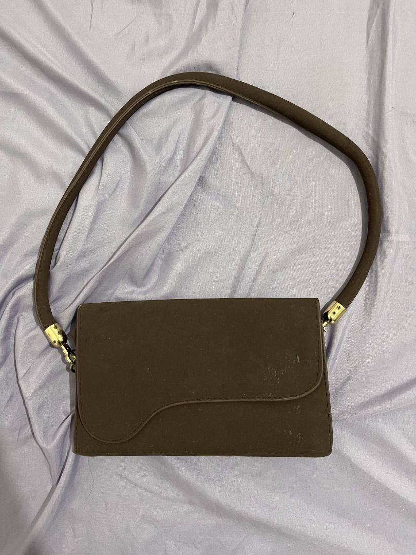 Brown Purse Bag (Category: Purses & Pouches) located in Mandaluyong City. Submitted by pabili.po.ng.alaala (Listing ID 1468789131, Image 2). Description: Brown Purse Bag 120 PHP - Color: Solid brown - Shape: Structured rectangular with asymmetric flap closure - Hardware: Gold-tone accents - Style: Versatile neutral earth tone, perfect for casual outings.