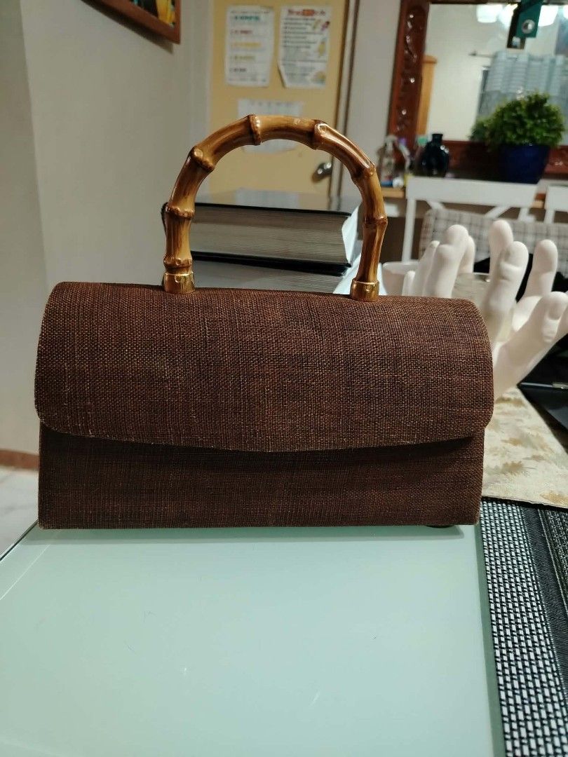 Brown woven handbag with bamboo handle (Category: Shoulder Bags) located in Paranaque City. Submitted by yensfashionfinds (Listing ID 1468740076, Image 1). Description: - Style: Textured brown handbag with a structured rectangular shape - Handle: Sturdy and stylish bamboo top handle - Hardware: Premium gold-tone accents throughout - Closure: Flap closure with a secure hidden magnetic snap - Interior: Light beige lining with a small side pocket an