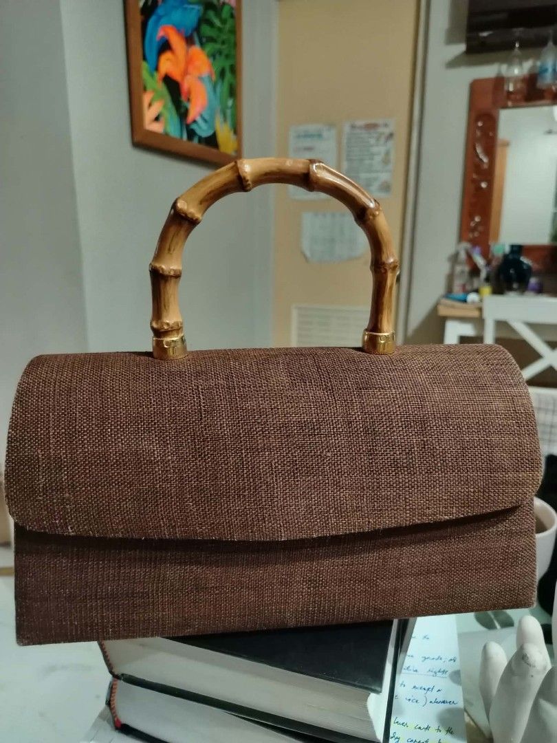 Brown woven handbag with bamboo handle (Category: Shoulder Bags) located in Paranaque City. Submitted by yensfashionfinds (Listing ID 1468740076, Image 2). Description: - Style: Textured brown handbag with a structured rectangular shape - Handle: Sturdy and stylish bamboo top handle - Hardware: Premium gold-tone accents throughout - Closure: Flap closure with a secure hidden magnetic snap - Interior: Light beige lining with a small side pocket an