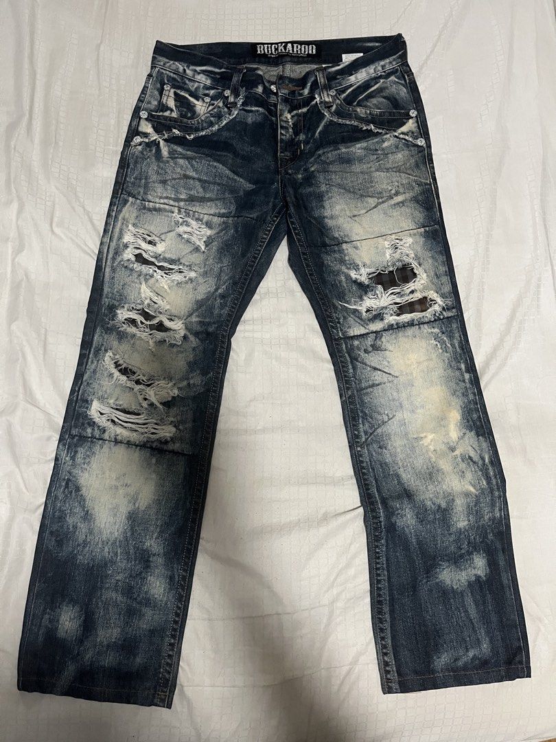 Buckaroo Distressed Acid Wash Denim (Category: Jeans) located in Manila. Submitted by chococoffeeboy (Listing ID 1468853943, Image 2). Description: - Buckaroo Original Vintage - Dark indigo acid wash - Details: Heavy distressing, ripped knees with checkered fabric patches, and frayed pocket edges - Accents: Studded embellishments on the back pocket and stylish paisley lining inside the waistband - Metal button fly closure Waist: 34” Length: 38.3”