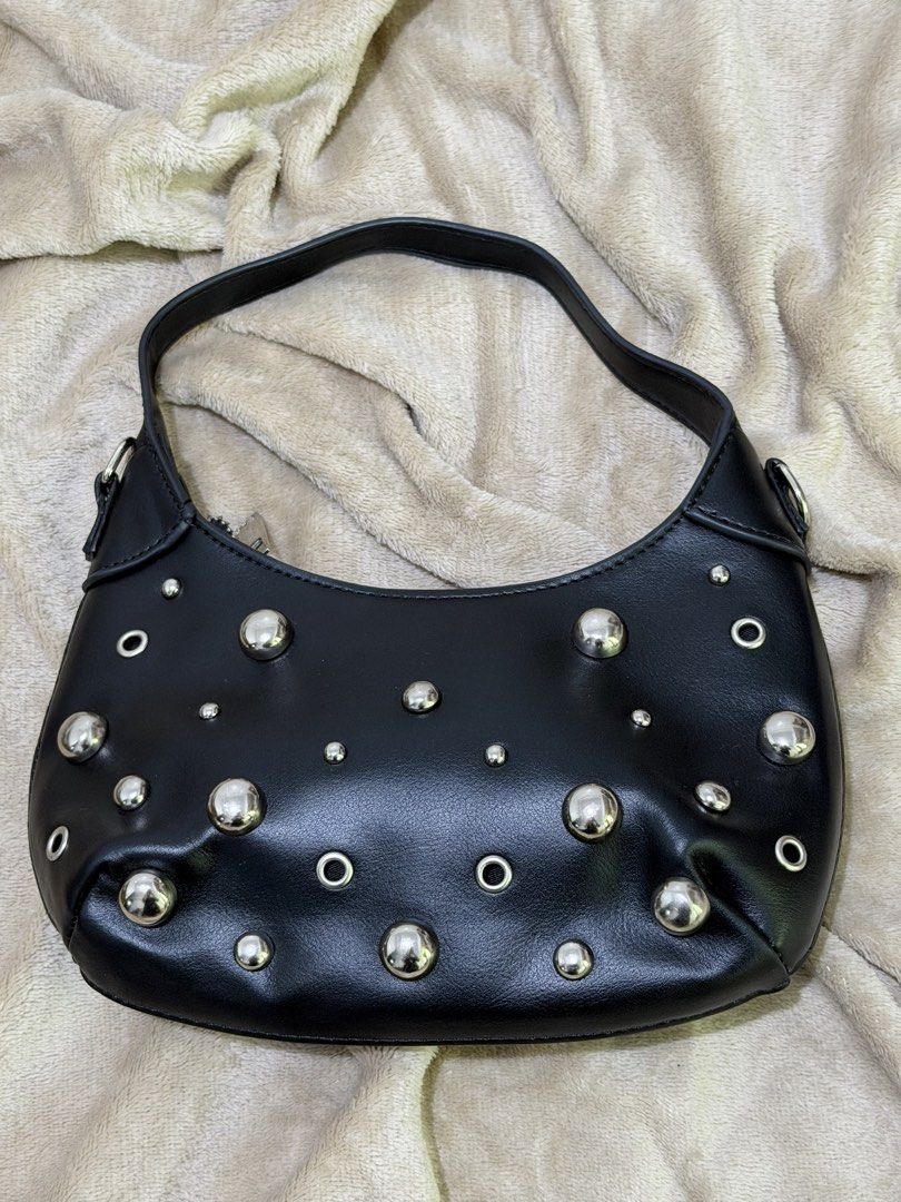 Calliope Black Studded Shoulder Bag (Category: Shoulder Bags) located in Manila. Submitted by declutterwtmaan (Listing ID 1468746633, Image 1). Description: - Brand: Calliope - Material: Black faux leather - Details: Silver-tone studs and grommets on the front - Closure: Zip top with metal pull - Interior: Clean black fabric lining with branded tag - Style: Compact, everyday shoulder bag USED ONCE.
