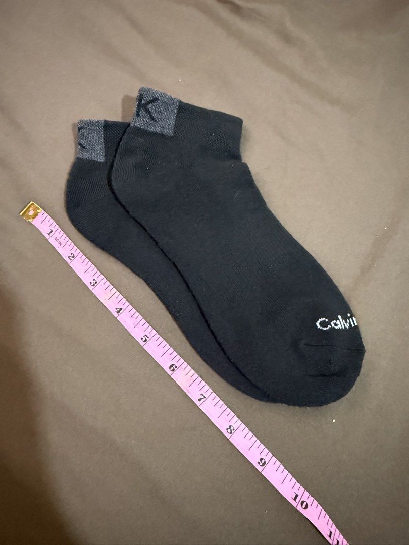 Calvin Klein Black Ankle Socks with CK Logo (Category: Socks) located in Quezon City. Submitted by turtleandfishes (Listing ID 1468737459, Image 3). Description: - Brand: Calvin Klein - Color: Black with contrast grey ribbed cuffs - Details: CK logo on back cuff, white text branding across the toe - Material: Soft knit fabric - Condition: Brand new / Excellent.
