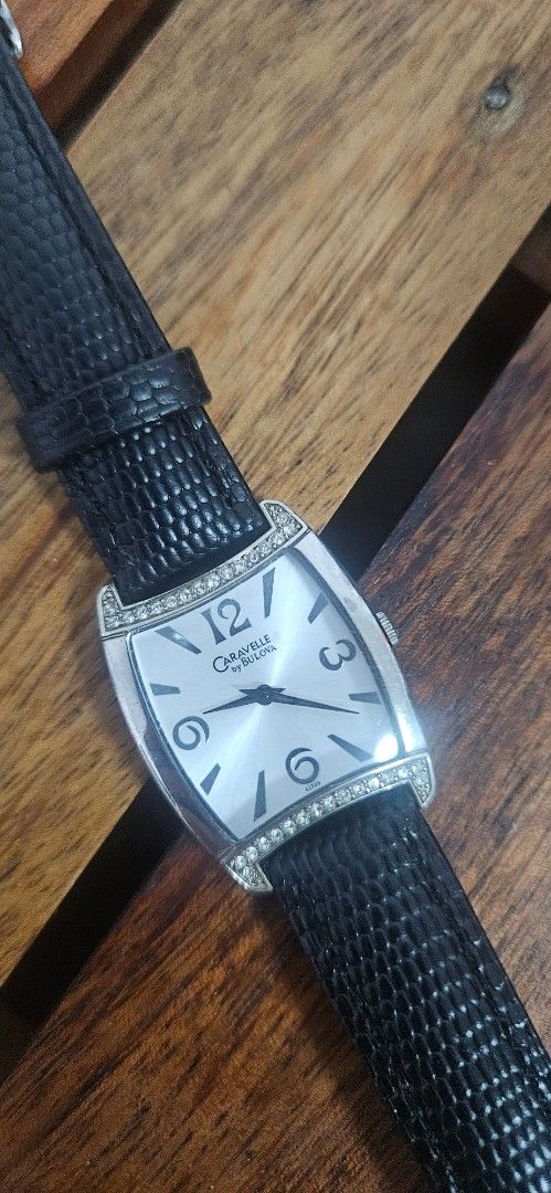 Caravelle by Bulova Watch (Category: Women's Watches) located in Santa Maria. Submitted by rommelmateo (Listing ID 1468861758, Image 1). Description: - Brand: Caravelle by Bulova - Dial: Silver with large numbers at 12, 3, 6, and 9 - Bezel: Rhinestone-encrusted top and bottom - Case: Curved rectangular stainless steel (standard light scuffs on the back from normal wear) - Strap: Textured black leather - Condition: Keeps time very well.