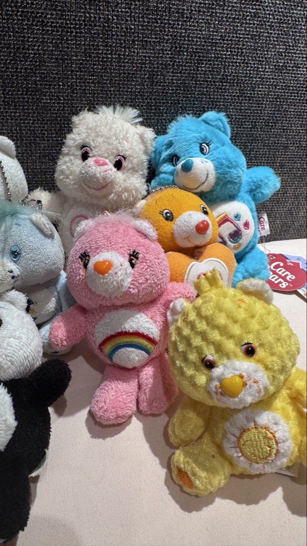 Care Bears plush keychain bundle lot of assorted bears (Category: Plushies & Soft Toys) located in Mandaluyong City. Submitted by maelovestoshop (Listing ID 1468873705, Image 3). Description: Bundle of assorted Care Bears plush toys and keychains. Features characters in different colors including pink with rainbow belly badge, yellow with sun emblem, blue with music notes, white, and a panda bear plush. Various sizes and styles with ball chains a