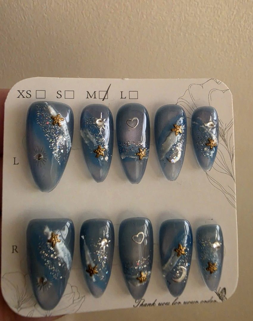 Cat's eye Celestial Blue Press-On Nails [M size] (Category: Hands & Nails) located in Cavite. Submitted by phoibee (Listing ID 1468783108, Image 1). Description: - Style: Celestial blue press-on nails with gold stars, silver moons, tiny hearts, glitter swirls, and rhinestones - only worn to fit the thumb. never used. - Size: Medium.